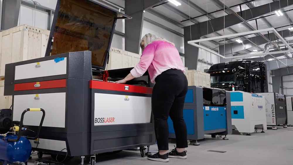 a women looking at a line up of several laser anriokita machines